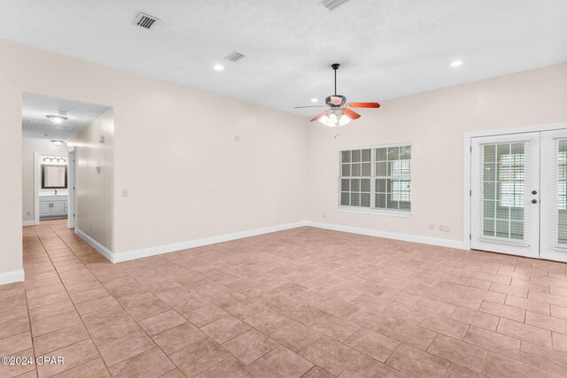 spare room featuring ceiling fan and french doors