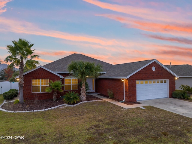 ranch-style home with a lawn and a garage