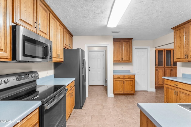 kitchen featuring hanging light fixtures, sink, a textured ceiling, appliances with stainless steel finishes, and a notable chandelier