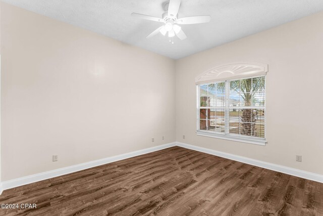 unfurnished bedroom with a textured ceiling, ceiling fan, a closet, and dark hardwood / wood-style floors