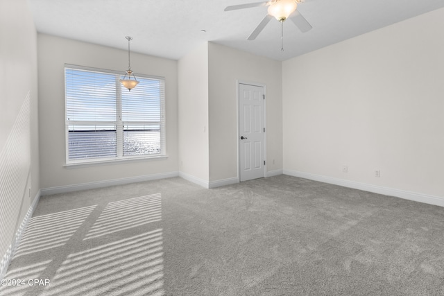 carpeted spare room featuring ceiling fan