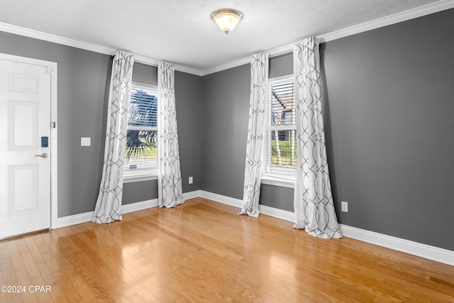 interior space featuring hardwood / wood-style floors, a textured ceiling, plenty of natural light, and crown molding