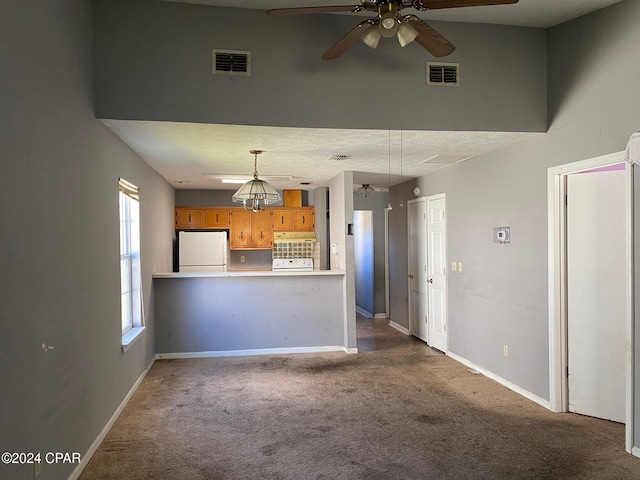 unfurnished living room with carpet flooring and ceiling fan with notable chandelier