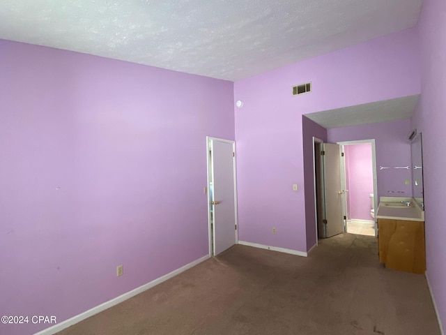 unfurnished bedroom featuring carpet flooring and a textured ceiling