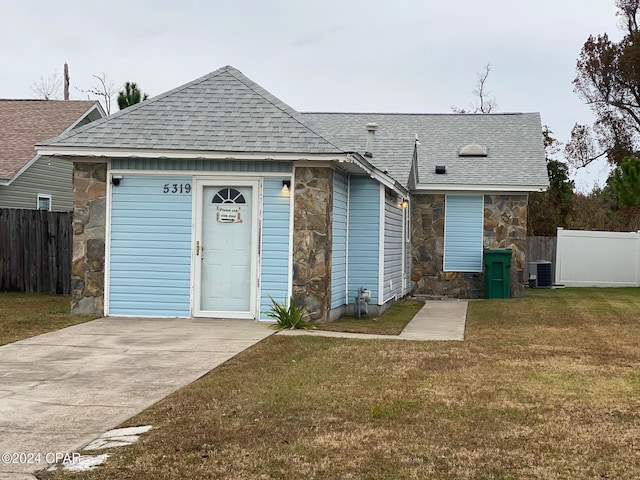 view of front facade featuring central AC unit and a front yard