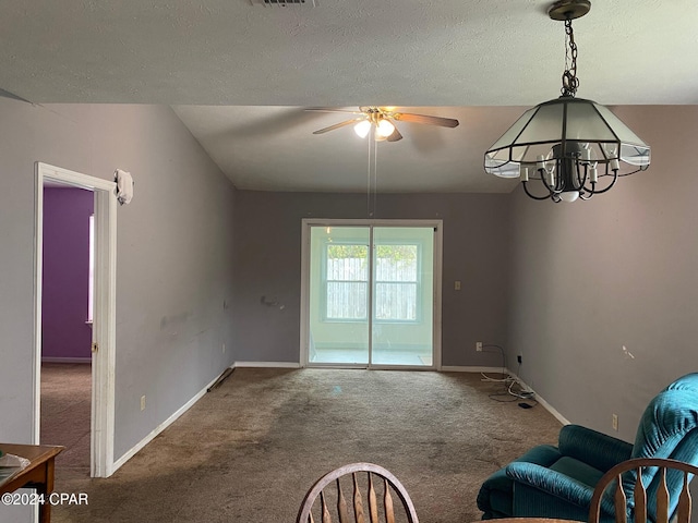 unfurnished living room with ceiling fan with notable chandelier and carpet floors