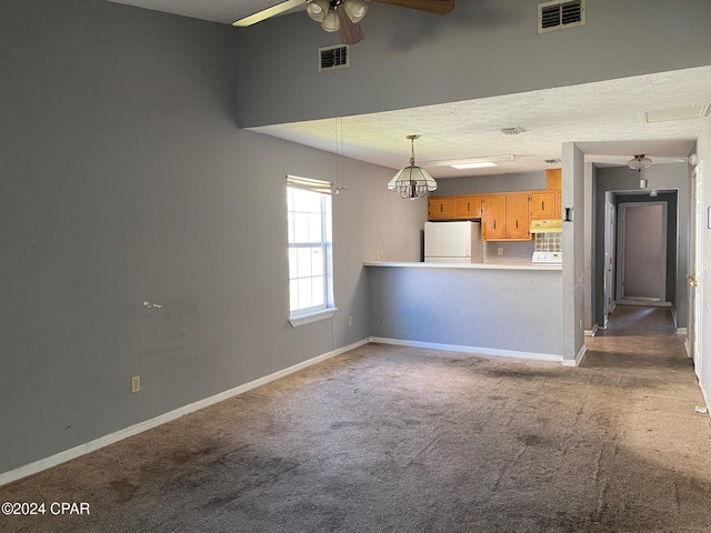 unfurnished living room featuring carpet flooring, ceiling fan, and a textured ceiling