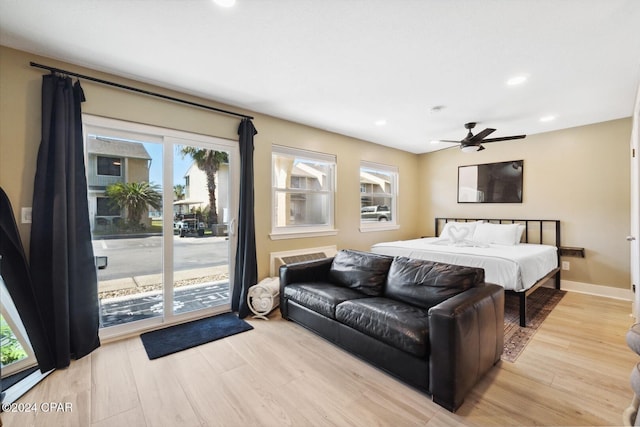 bedroom with access to exterior, light hardwood / wood-style floors, multiple windows, and ceiling fan