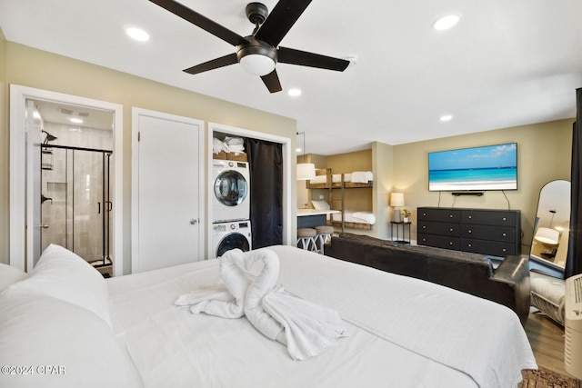 bedroom featuring hardwood / wood-style flooring, stacked washer / drying machine, ceiling fan, and connected bathroom