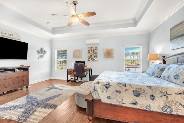 bedroom with ceiling fan, multiple windows, and a tray ceiling