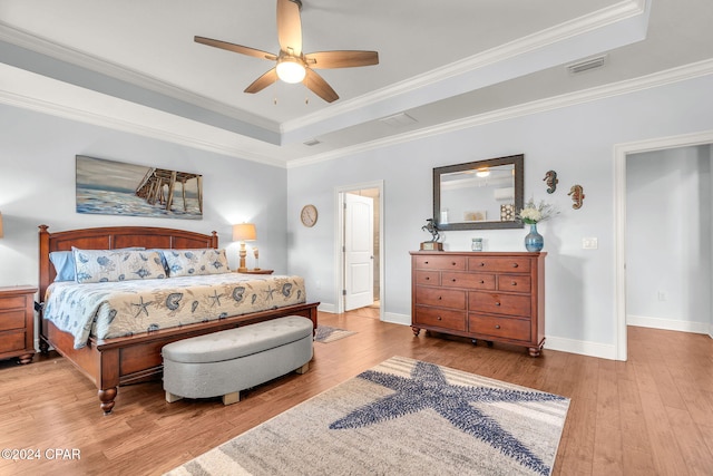 bedroom featuring ceiling fan, crown molding, and a tray ceiling