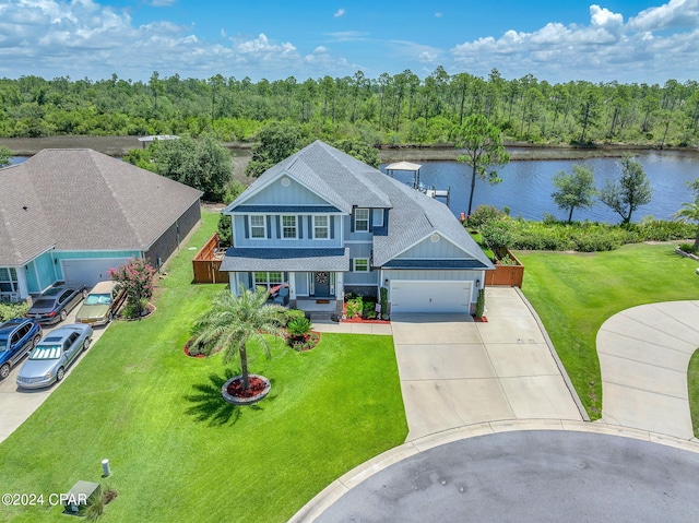 view of front of house with a front yard, a porch, a water view, and a garage