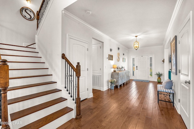 entryway with a chandelier, dark hardwood / wood-style flooring, and crown molding