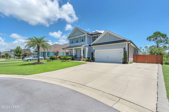 view of front of house with a porch, a front yard, and a garage