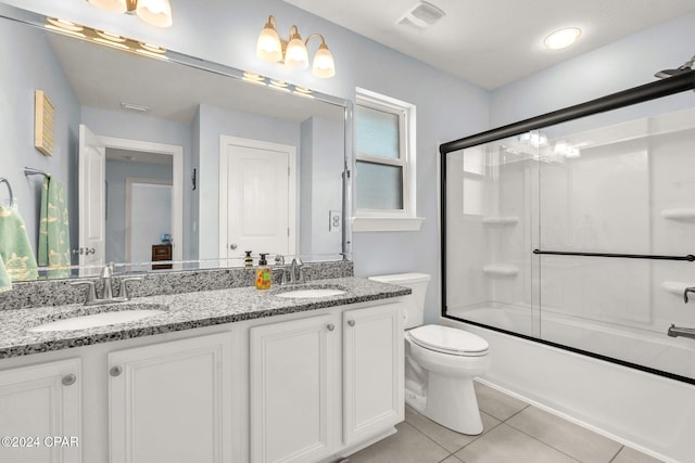 full bathroom with tile patterned floors, vanity, toilet, and bath / shower combo with glass door