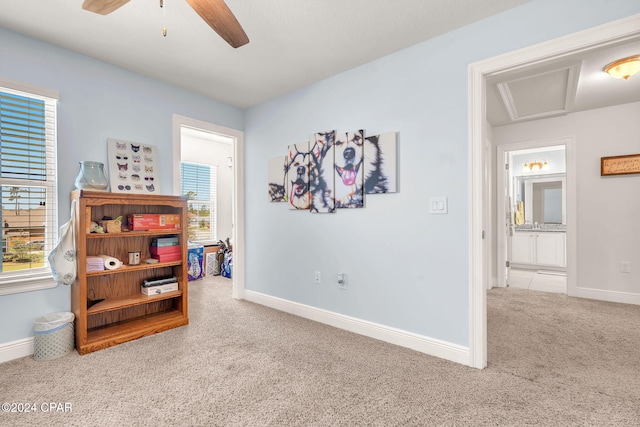 interior space with light colored carpet, plenty of natural light, and ceiling fan