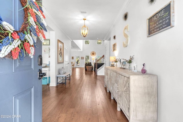 hall featuring ornamental molding, dark hardwood / wood-style floors, and a notable chandelier