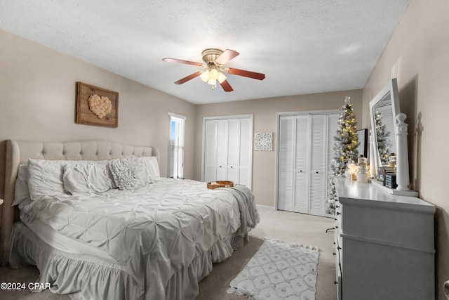 7707 Shadow Bay Dr, Panama City, FL 32404 - bedroom with ceiling fan, a textured ceiling, light carpet, and two closets