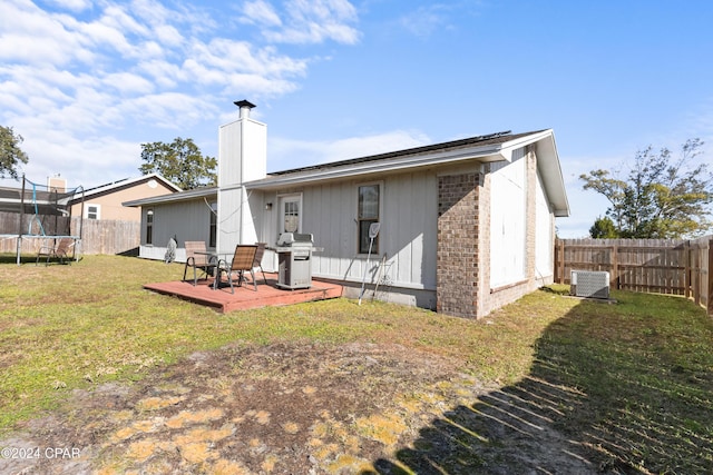 7707 Shadow Bay Dr, Panama City, FL 32404 - back of house featuring a yard, a trampoline, and central air condition unit