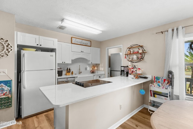 7707 Shadow Bay Dr, Panama City, FL 32404 - kitchen featuring white cabinetry, appliances with stainless steel finishes, kitchen peninsula, and light hardwood / wood-style floors