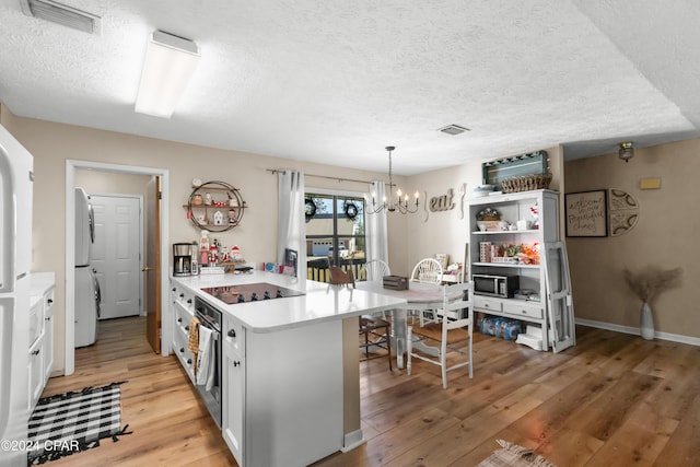 7707 Shadow Bay Dr, Panama City, FL 32404 - kitchen with stainless steel appliances, a kitchen breakfast bar, decorative light fixtures, a chandelier, and light wood-type flooring