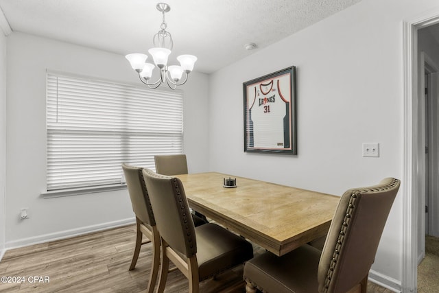 dining room featuring hardwood / wood-style floors, a chandelier, and a textured ceiling