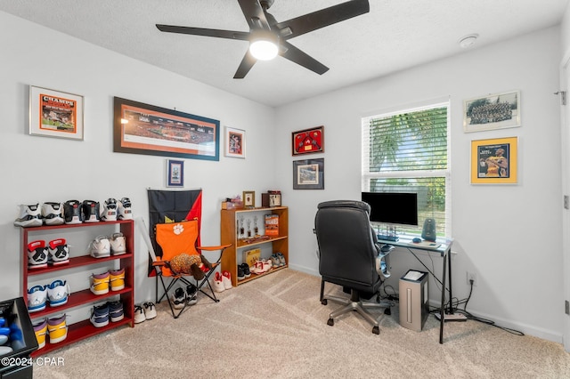 carpeted office space with a textured ceiling and ceiling fan