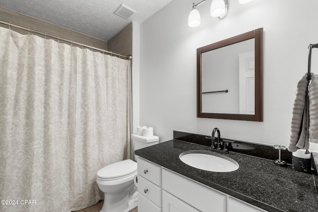 bathroom featuring vanity, toilet, and a textured ceiling