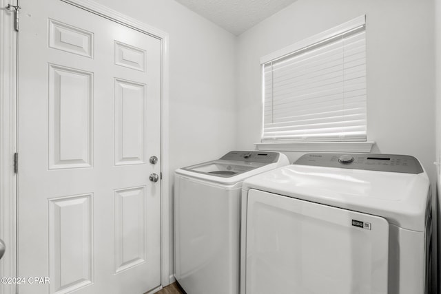 washroom with washing machine and clothes dryer and a textured ceiling