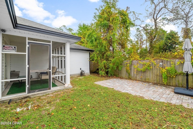 view of yard featuring a sunroom and a patio