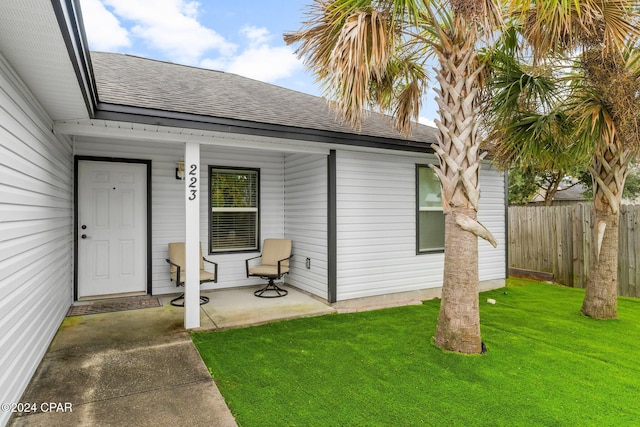 doorway to property featuring a lawn and a porch