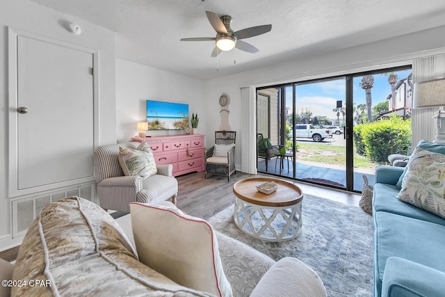 living room featuring wood-type flooring, french doors, and ceiling fan