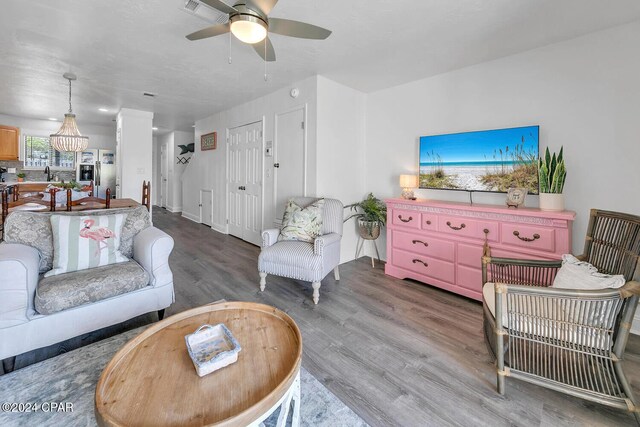 living room with wood-type flooring, ceiling fan, and sink