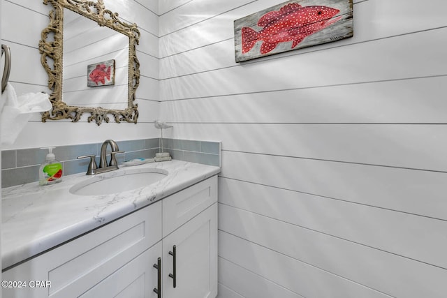 bathroom featuring vanity and tile walls