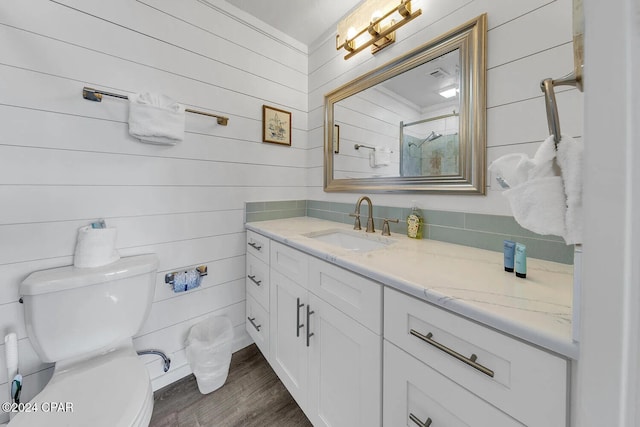 bathroom with vanity, hardwood / wood-style flooring, toilet, and wood walls