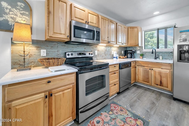 kitchen with light brown cabinetry, dark hardwood / wood-style flooring, tasteful backsplash, stainless steel appliances, and sink