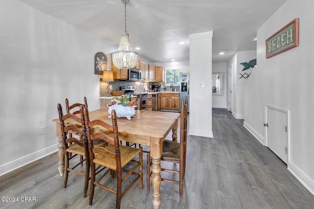 dining area featuring dark hardwood / wood-style flooring, an inviting chandelier, and sink