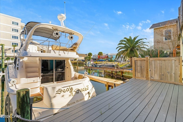 wooden terrace featuring a water view and a boat dock