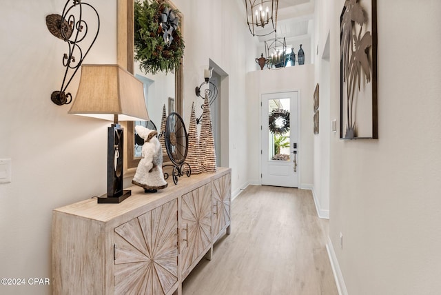 doorway featuring a high ceiling and light hardwood / wood-style flooring