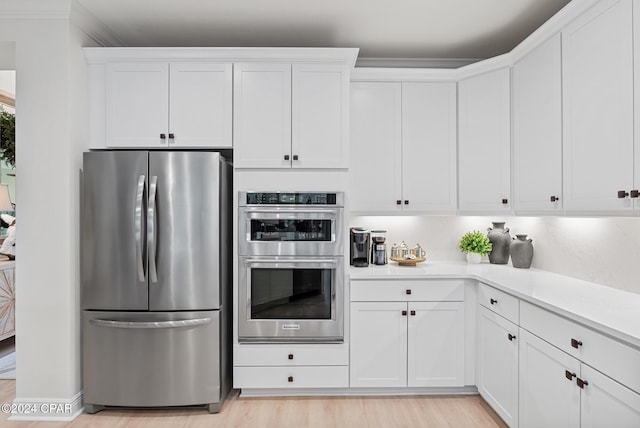 kitchen with white cabinets, stainless steel appliances, and light wood-type flooring