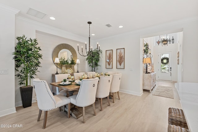 dining room with a chandelier, crown molding, and light hardwood / wood-style flooring