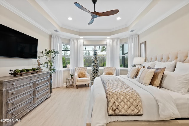 bedroom featuring light hardwood / wood-style floors, a raised ceiling, ceiling fan, and ornamental molding