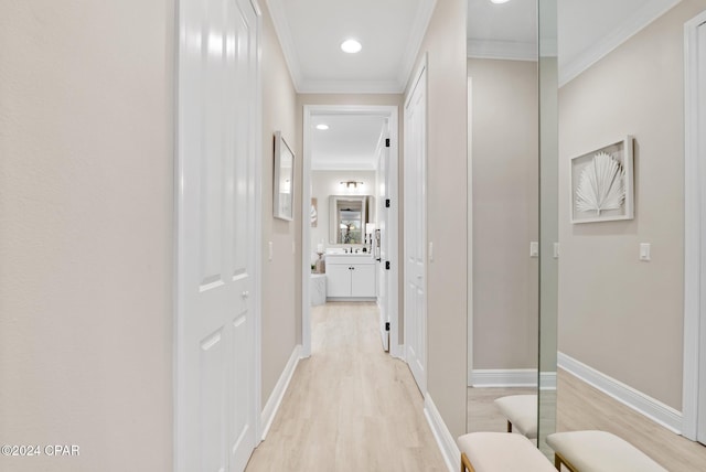 hall with light hardwood / wood-style flooring and ornamental molding