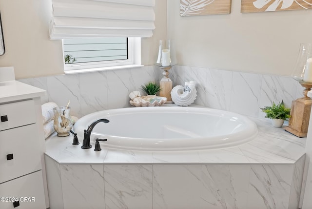 bathroom featuring vanity and tiled bath