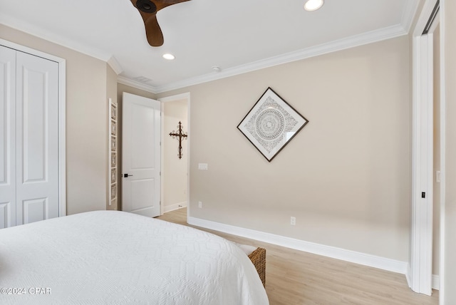 bedroom with ceiling fan, a closet, crown molding, and hardwood / wood-style flooring