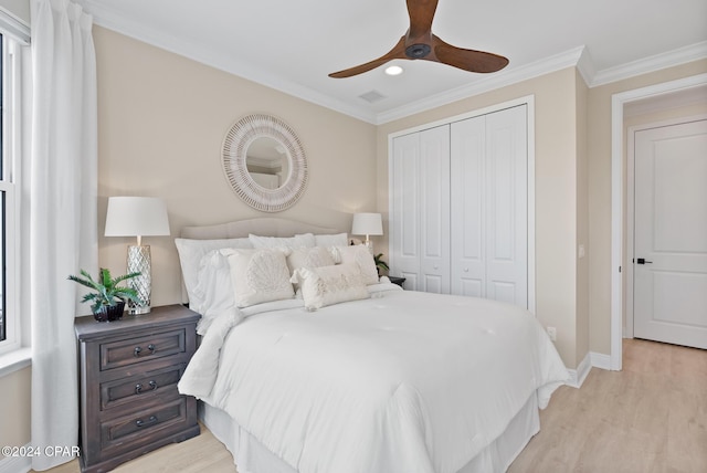 bedroom with ceiling fan, a closet, light hardwood / wood-style floors, and ornamental molding