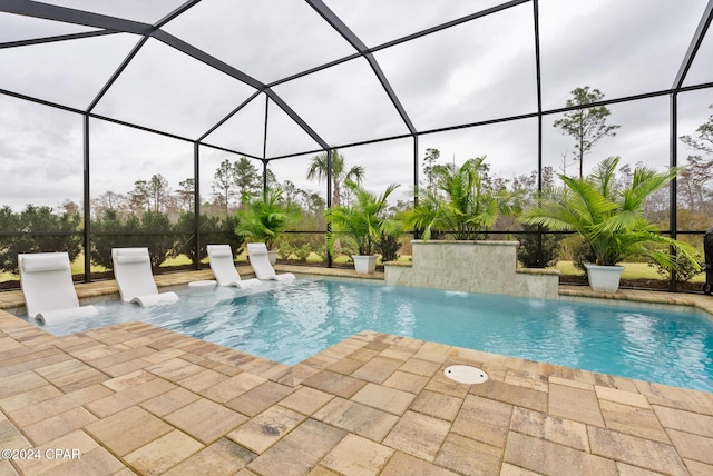 view of pool featuring pool water feature, glass enclosure, and a patio