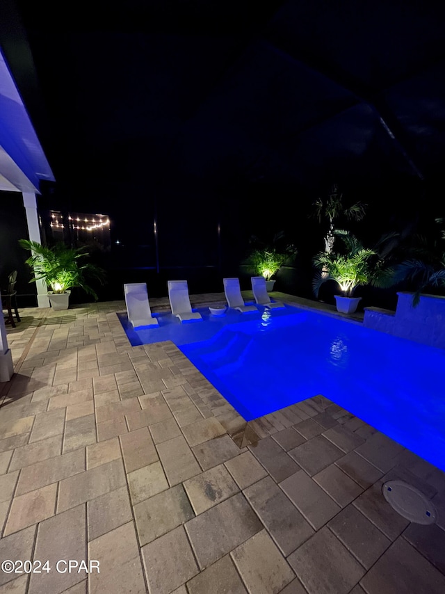 pool at night with a patio