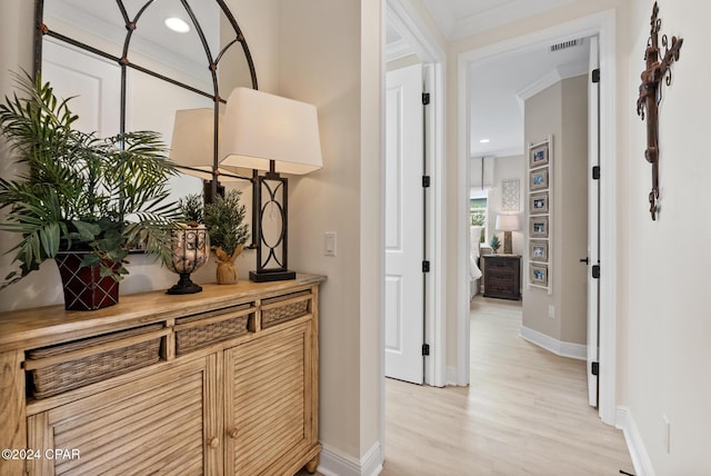 hall featuring ornamental molding and light hardwood / wood-style flooring