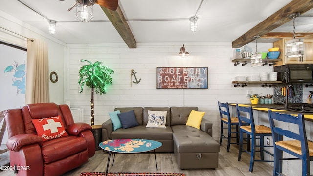 living room featuring sink, hardwood / wood-style flooring, ceiling fan, and beam ceiling